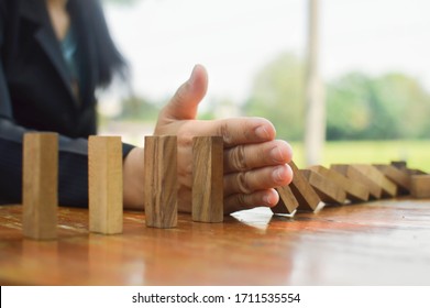 Close-up of a businesswoman's hand, the stopping of Domino's wood is the result of continuous subversion or risk, strategies and successful interventions for business.
