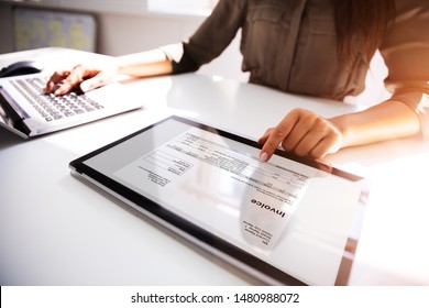 Close-up Of A Busineswoman's Hand Working With Invoice On Digital Tablet