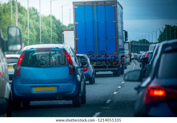 Closeup of busy Highway\
transportation  motorway full of cars in the evening with dark\
cloudy blue sky