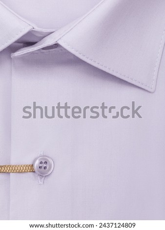 Close-up of a button placket on a light purple men's dress shirt, top view