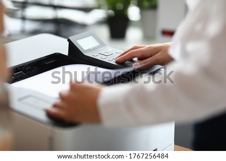 Close-up of cabinet worker using printer for working moment. Person in stylish white shirt. Device for office work. Man pressing button. Business and successful company concept