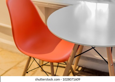 Closeup Of Cafe Interior. Plastic Orange Chair And Round White Table In Modern Style