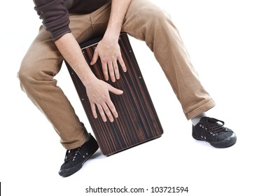 Close-up of a cajon, man's legs and hands are shown as he's playing the instrument - isolated on white