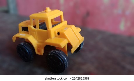 Closeup Of A Cake In The Shape Of A Yellow Children's Toy Car, Smooth Background. High Photo Quality.