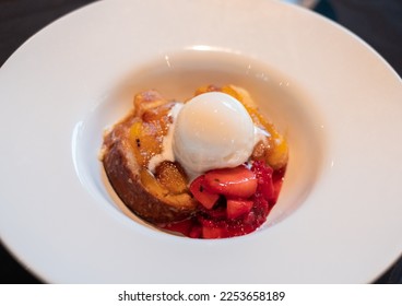 Close-up of cake with strawberries and ice-cream on white plate.  - Shutterstock ID 2253658189