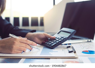Close-up calculator  to calculate the company's financial results On the wooden table in the office and business work background, tax, accounting, statistics, and analytical research concept