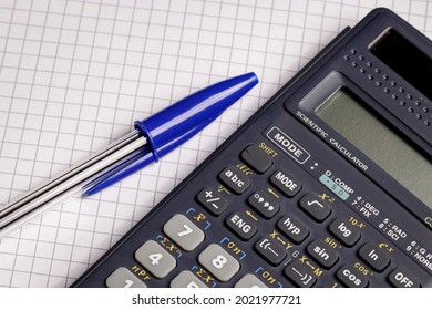 Close-up Of A Calculator On Squared Paper Background For Math, Physics, Engineering Or Business Homework And Tax And Finance Calculations 