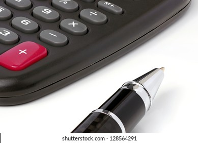 Closeup of a calculator and a pen.