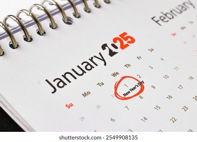 A close-up of a calendar page for January 2025, with the first day of the month, January 1st, circled in red and labeled "New Year's Day." - Powered by Shutterstock