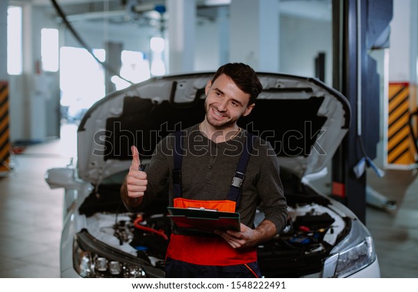 Closeup to\
the camera, mechanic man holding a map of documents then looking\
straight to the camera and showing a big\
like
