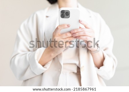 Close-up camera phone. Three cameras on a smartphone. Women's well-groomed hands with a beautiful manicure hold a modern top-end smartphone. Business concept.
