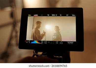 Closeup of camera screen with two actors interacting on set, backstage scene, copy space
