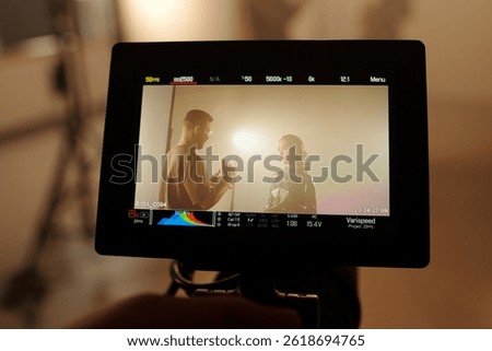 Closeup of camera screen with two actors interacting on set, backstage scene, copy space