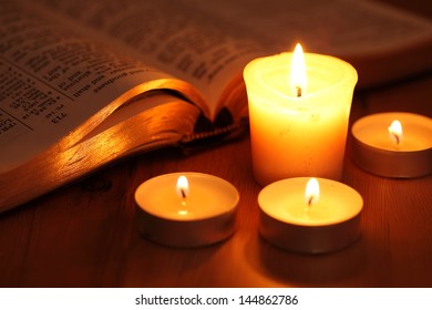 Close-up Of Candles And Open Bible. 