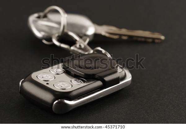 Close-up of a car alarm remote control and car\
keys on a black\
background