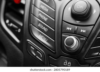Close-up of car audio control panel with buttons and knob