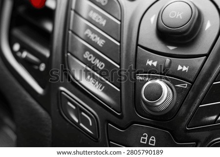 Close-up of car audio control panel with buttons and knob