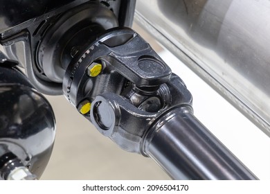 Closeup of a car cardan drive shaft with cardan cross joint and intermediate bearing support. Also known as universal joint, u-joint or cardan joint. Part of the transmission of a truck