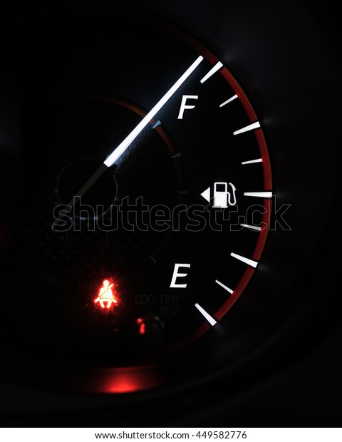 Close-up car dash board petrol\
meter, fuel gauge, on black background with over full gasoline in\
car or vehicle with red light of fasten seatbelt warning sign on\
.