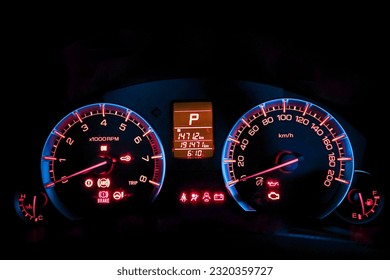 Close-up of car dashboard showing indicator light icon before starting engine. The car dashboard displays colorful symbols at night when the engine is started.