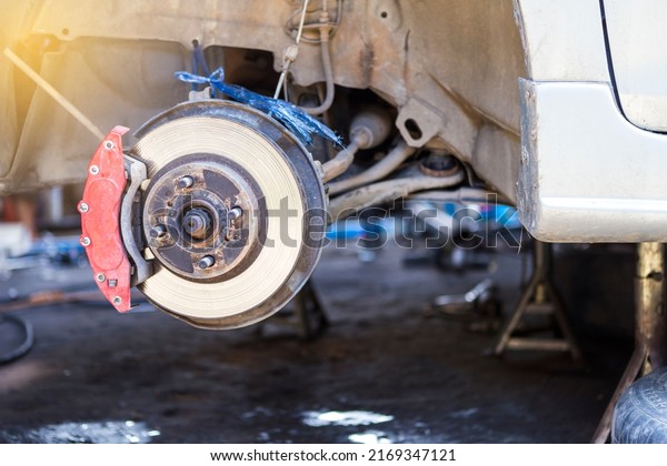 Closeup car disk brake repair in garage, Wheel\
brake system problem, car\
safety