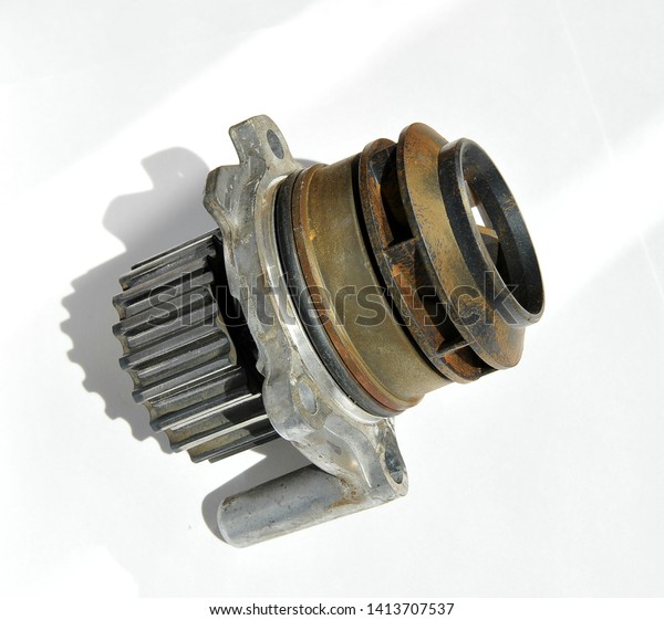 Closeup of a\
car engine cooling system pump on a white background. Working,\
natural, metal pump engine cooling system of the car. Plastic\
impeller pump. Spare part of the car\
engine.