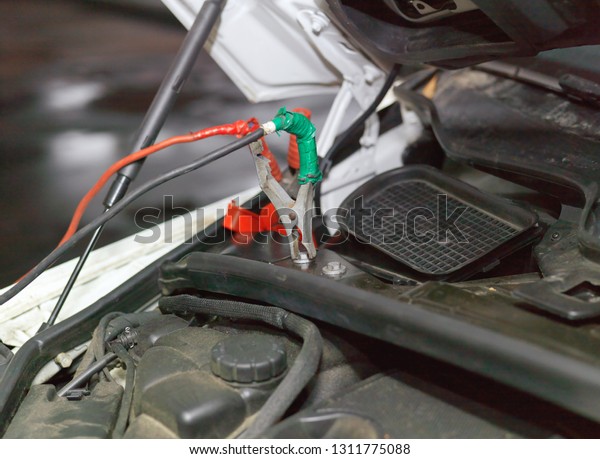 Closeup of a car\
engine start with jump\
leads