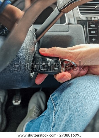 A close-up of a car key being inserted into the ignition. Vertical photo.
