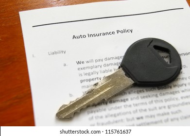 Closeup Of A Car Key On An Auto Insurance Policy