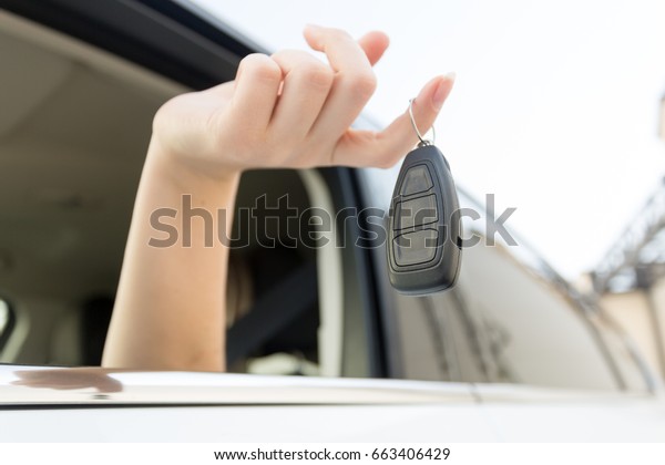 Closeup of car keys\
hanging on female\
finger