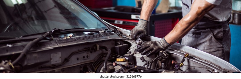 Close-up of car mechanic fixing automotive engine