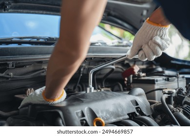 Close-up of Car mechanic noting repair parts during open car hood engine repair unrecognisable man wearing gray glove inspecting car engine and interior of hood of car. at garage.   - Powered by Shutterstock