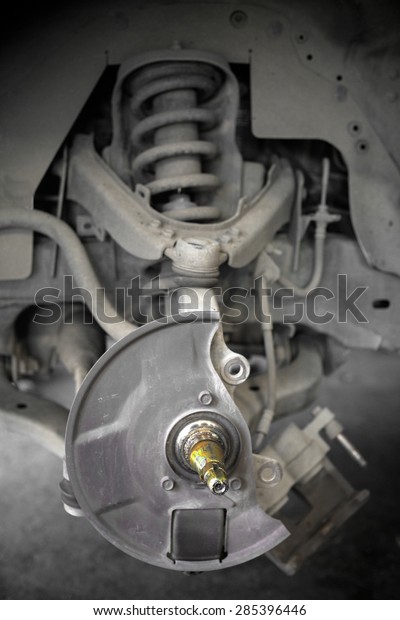 Closeup of car\
mechanic repairing brake\
pads