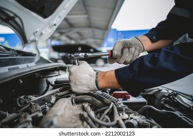 Close-up Of A Car Mechanic Repairing A Car In A Garage. Car Safety Check The Engine In The Garage. Repair Service Concept.