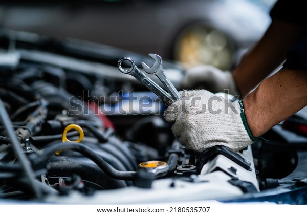 Close-up of\
a car mechanic repairing a car in a garage. car safety check The\
engine in the garage. Repair service\
concept.