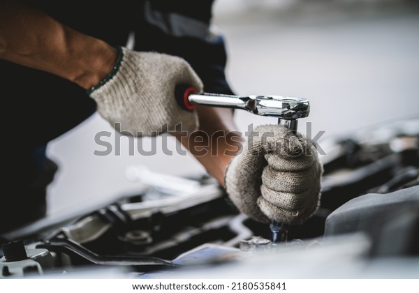 Close-up of\
a car mechanic repairing a car in a garage. car safety check The\
engine in the garage. Repair service\
concept.