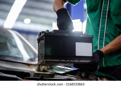 Close-up of a car mechanic in a service center picking up a new battery to replace the car. for cars that use the service Replace the battery at the store - Shutterstock ID 2168533863