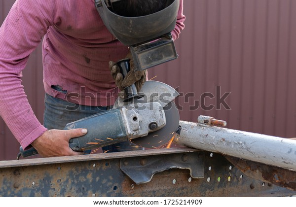 A\
close-up of a car mechanic using a metal grinder to cut a car\
bearing in an auto repair shop, bright flashes flying in different\
directions, in the background tools for an auto\
repair
