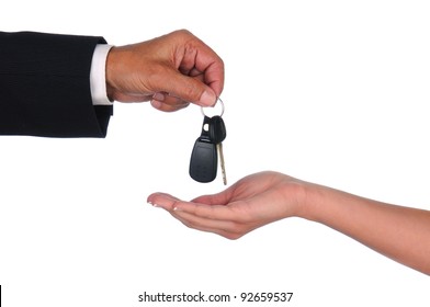 Closeup Of A Car Salesman Dropping Keys Into A Woman's Waiting Hand. Horizontal Format Showing Hands Only Over A White Background