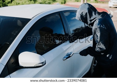Close-up car thief hand holding screwdriver tamper yank and glove black. Man robber checking breaking entering alarm in a car stealing. Image about reflect society.