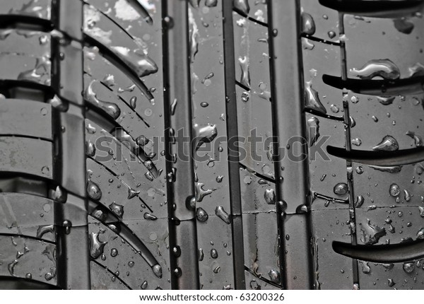 Close-up\
of car tire with with water drops to\
background