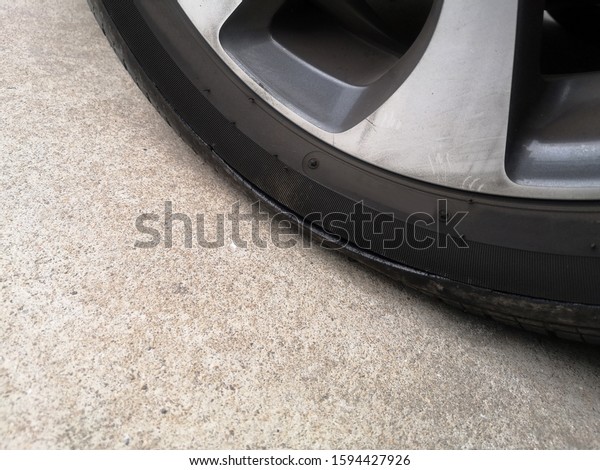 Close-up car tires have a tear on the sidewall. Flat\
tire on a car