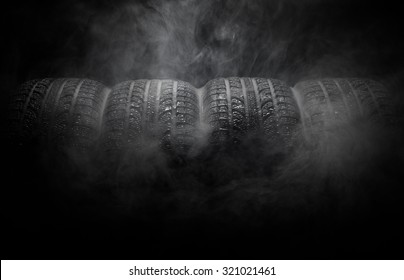 Close-up Of Car Tires With Smoke Over Black Background