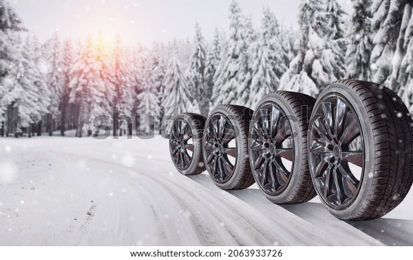 Closeup of car tires in winter on the road\
covered with snow - winter tire change\
concept