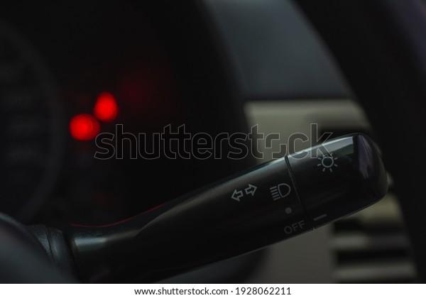 Closeup car\
turn signal lever on dark\
background.