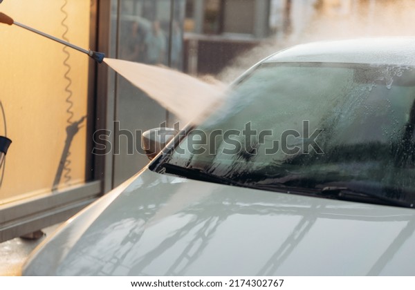 Close-up of a car under the water jet\
during the washing process on a self service car\
wash