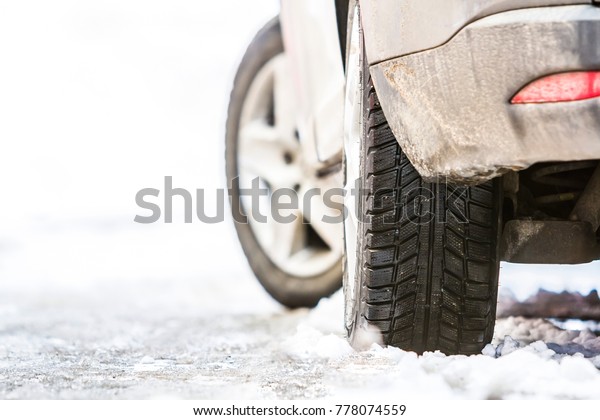 Close-up of car\
wheel in winter tire on snowy\
road