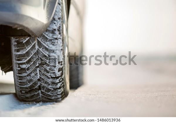 Close-up of car wheels rubber tire in deep snow.\
Transportation and safety\
concept.