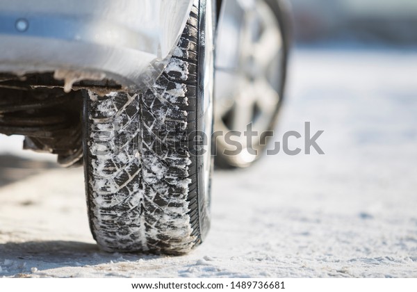 Close-up of car wheels rubber tire in deep snow.\
Transportation and safety\
concept.