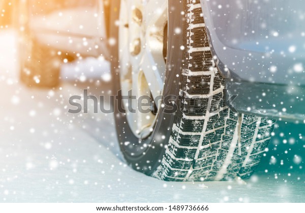 Close-up of car wheels rubber tires in\
deep winter snow. Transportation and safety\
concept.